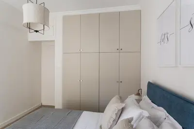a bedroom with a bed with white cabinets at Pristine 1BR Apartment in Ampelokipoi Area by UPSTREET in Athens