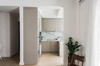 a white kitchen with a sink and a counter at Pristine 1BR Apartment in Ampelokipoi Area by UPSTREET in Athens
