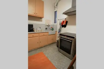 a kitchen with wooden cabinets and a stove top oven at Georgia's Cozy Apartment in Koukaki in Athens