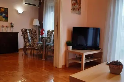 a living room with a television and a table with chairs at Georgia's Cozy Apartment in Koukaki in Athens