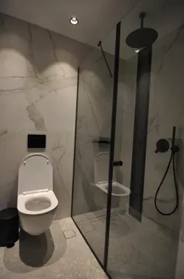 a bathroom with a white toilet and a shower at Athinaion Recreation Suites in Athens