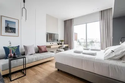 a bedroom with a large bed and a couch at Athinaion Recreation Suites in Athens