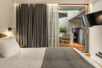 a bedroom with a bed and a living room at Athens Dom Hotel in Athens
