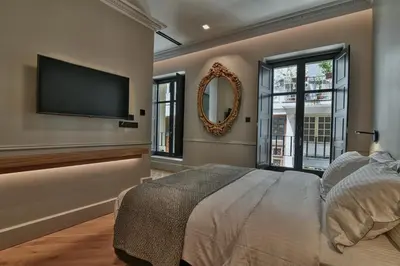 a bedroom with a large bed and a flat screen tv at Athens Dom Hotel in Athens