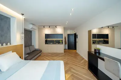 a bedroom with a bed and a living room at Triple A - Between 3 Squares - Monastiraki & Syntagma & Psiry - FREE Parking! in Athens