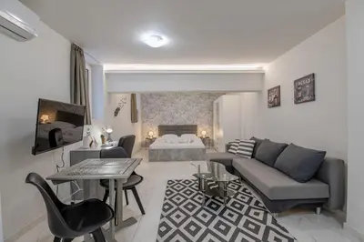 a living room with a couch and a bed at Paleo Faliro Gardenbay in Athens