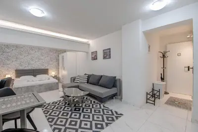 a living room with a bed and a couch at Paleo Faliro Gardenbay in Athens