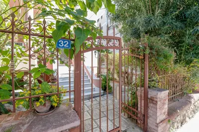 an iron gate with a sign on it in a garden at Paleo Faliro Gardenbay in Athens