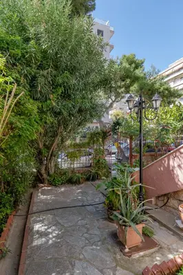 a garden with a fence and trees and a street light at Paleo Faliro Gardenbay in Athens