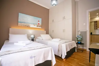 a bedroom with two beds and a painting on the wall at Semeli by Heloni Apartments in Athens