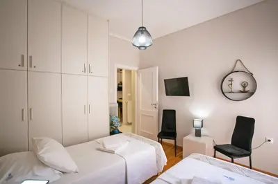 a bedroom with two beds and a tv and a mirror at Semeli by Heloni Apartments in Athens