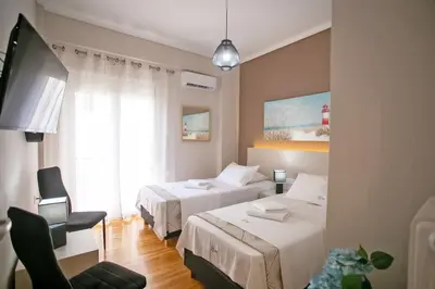 a hotel room with two beds and a chair at Semeli by Heloni Apartments in Athens