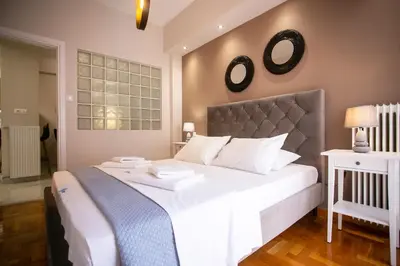 a bedroom with a large white bed with two mirrors on the wall at Semeli by Heloni Apartments in Athens