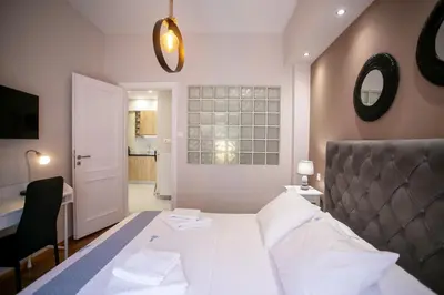 a bedroom with a bed and a desk and a mirror at Semeli by Heloni Apartments in Athens