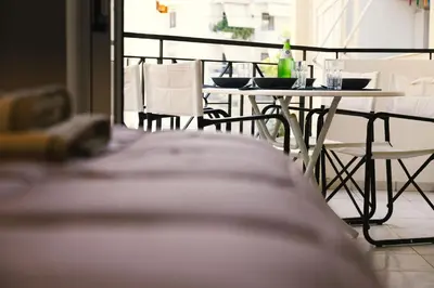 a table and chairs with bottles and glasses on it at Spacious apartment close to the sea and the city center in Athens