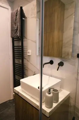 a bathroom with a white sink and a shower at Spacious apartment close to the sea and the city center in Athens
