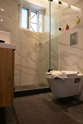 a bathroom with a shower and a toilet and a sink at Spacious apartment close to the sea and the city center in Athens