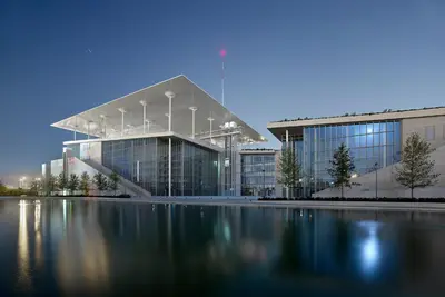 a large glass building with a reflecting pool in front of it at Spacious apartment close to the sea and the city center in Athens