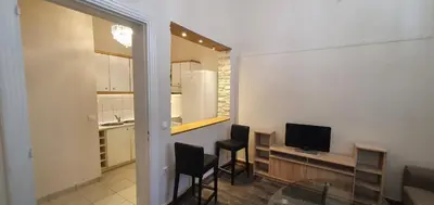 a living room with a table and chairs and a television at Beauty of Central Athens 60sqm in Athens
