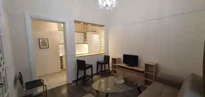 a living room with a couch and a table and a television at Beauty of Central Athens 60sqm in Athens