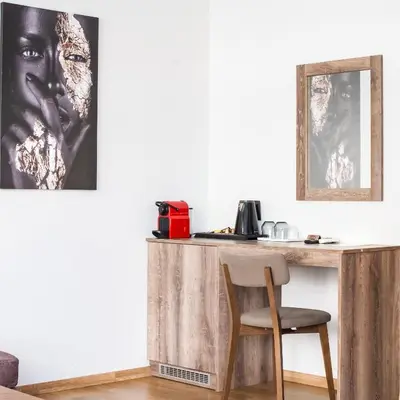 a wooden desk with a chair and a picture on the wall at Iasonos Suites Athens in Athens