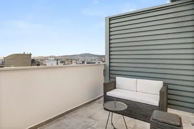 a white chair sitting on a balcony with a view at ATHENIAN VIEW LOFT in Athens