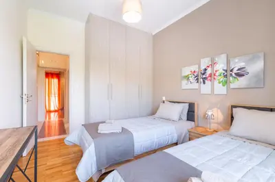 a bedroom with two beds and a table with a desk at Katsanis luxury apt., stunning view of acropolis in Athens