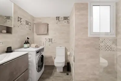 a bathroom with a washing machine and a toilet at Katsanis luxury apt., stunning view of acropolis in Athens
