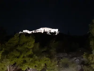 a white building on top of a mountain at night at Katsanis luxury apt., stunning view of acropolis in Athens