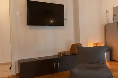 a living room with a couch and a tv on a wall at Athenian Port Luxury Apartment 1/Piraeus Riviera in Piraeus