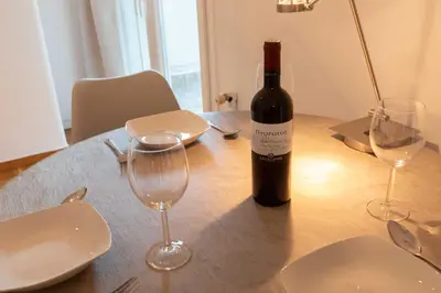 a bottle of wine sitting on a table with glasses at Athenian Port Luxury Apartment 1/Piraeus Riviera in Piraeus