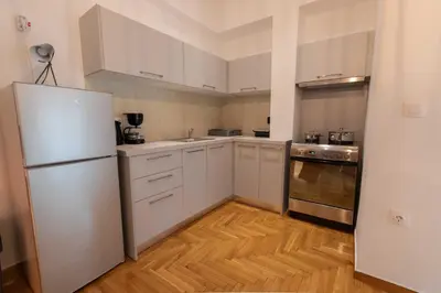 a kitchen with white cabinets and a refrigerator at Athenian Port Luxury Apartment 1/Piraeus Riviera in Piraeus