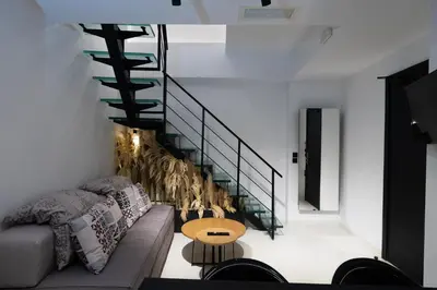 a living room with a couch and a staircase at The Fountain Athens in Athens