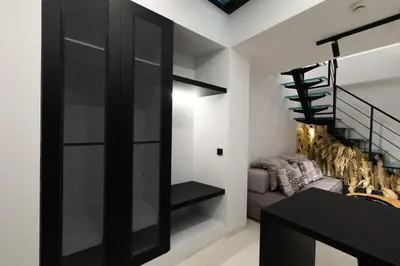 a living room with a staircase and a black door at The Fountain Athens in Athens