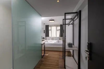 a bathroom with a glass door leading to a bedroom at The Fountain Athens in Athens