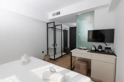 a room with a bed and a desk with a television at The Fountain Athens in Athens