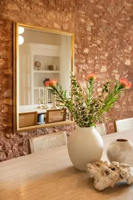 a vase with flowers on a table in front of a mirror at Villa Terra Mare in Vari