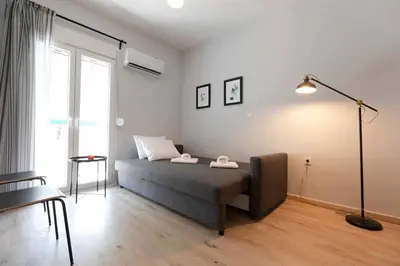 a bedroom with a bed and a lamp and a window at The brand new House meets the ideal location Apt2 in Athens