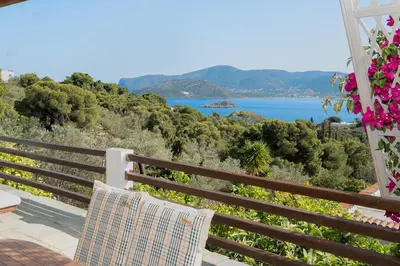 a bench on a balcony with a view of the ocean at Villa Beis in Porto Rafti