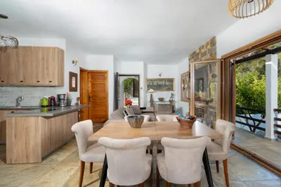 a kitchen and dining room with a wooden table and chairs at Villa Beis in Porto Rafti