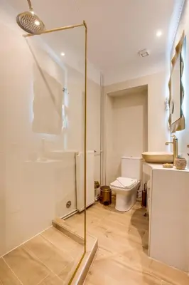 a bathroom with a toilet and a glass shower at Pandrosos Divine Suites in Athens