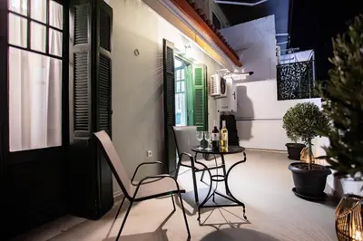 a small balcony with a table and chairs on it at Pandrosos Divine Suites in Athens