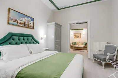 a bedroom with a large bed with a green headboard at Pandrosos Divine Suites in Athens