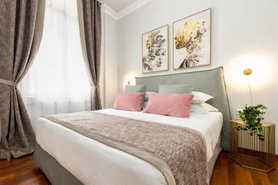 a bedroom with a large bed with two pink pillows at Asty Luxury Apartments in Athens