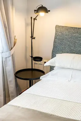 a bedroom with a bed and a table and a lamp at Asty Luxury Apartments in Athens