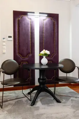 a table with two chairs and a vase of flowers on it at Asty Luxury Apartments in Athens