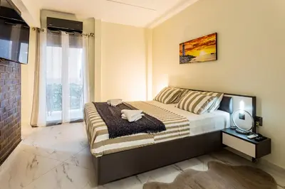 a bedroom with a bed and a large window at ROMANTIC DELUXE SVITE wise Jacuzzi and Sauna in Athens