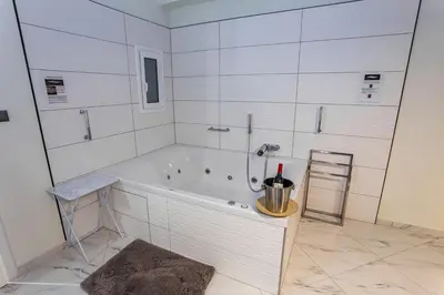 a white bathroom with a tub and a sink at ROMANTIC DELUXE SVITE wise Jacuzzi and Sauna in Athens