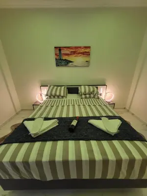 a bed with two plates and a remote control on it at ROMANTIC DELUXE SVITE wise Jacuzzi and Sauna in Athens