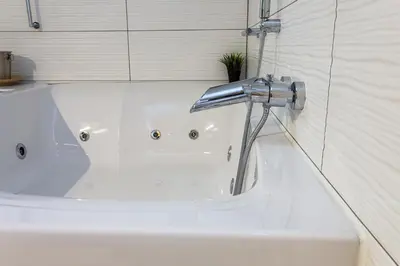 a white bath tub with a faucet in a bathroom at ROMANTIC DELUXE SVITE wise Jacuzzi and Sauna in Athens